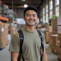 Young male entrepreneur smiling in warehouse environment, representing chak.ai student success