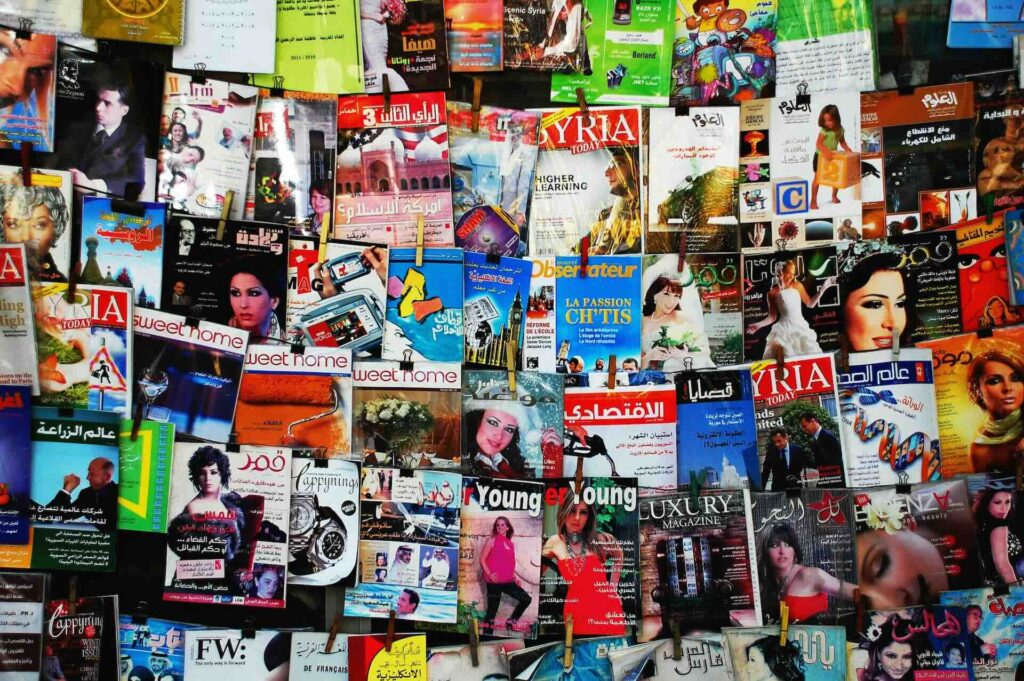 A wall covered in a diverse array of colorful magazines, representing the wide variety of content formats available for marketing.