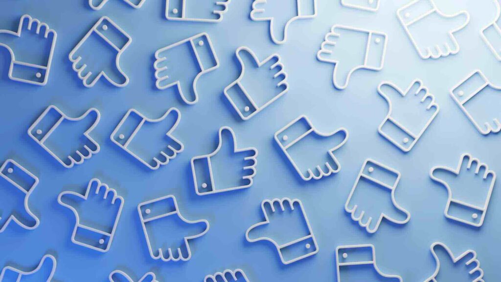 A pattern of 3D 'thumbs up' and 'thumbs down' icons, representing audience feedback and engagement on social media.